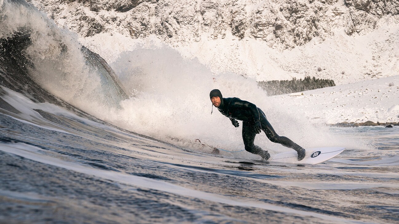 Chris Hemsworth surfs a wave. (National Geographic for Disney+/Craig Parry)