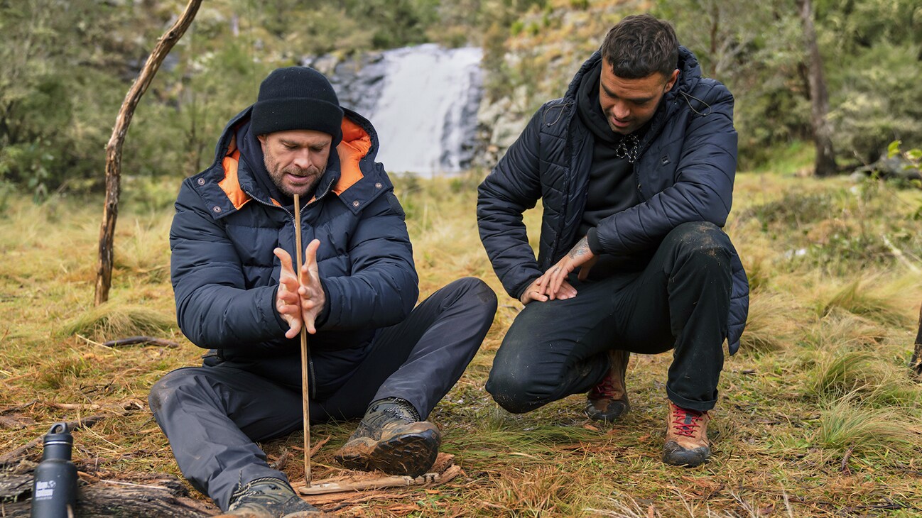 Chris Hemsworth and Otis Carey start a fire. (National Geographic for Disney+/Craig Parry)