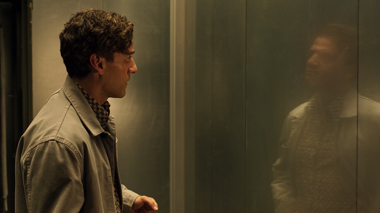 Image of Steven Grant/Marc Spector (actor Oscar Isaac) staring at a reflection from Marvel Studios' "Moon Knight".