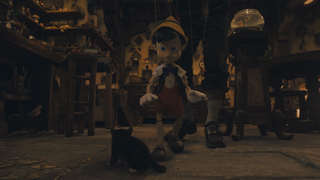 (L-R): Figaro and Pinocchio (voiced by Benjamin Evan Ainsworth) in Disney's live-action PINOCCHIO, exclusively on Disney+. Photo courtesy of Disney Enterprises, Inc. © 2022 Disney Enterprises, Inc. All Rights Reserved.