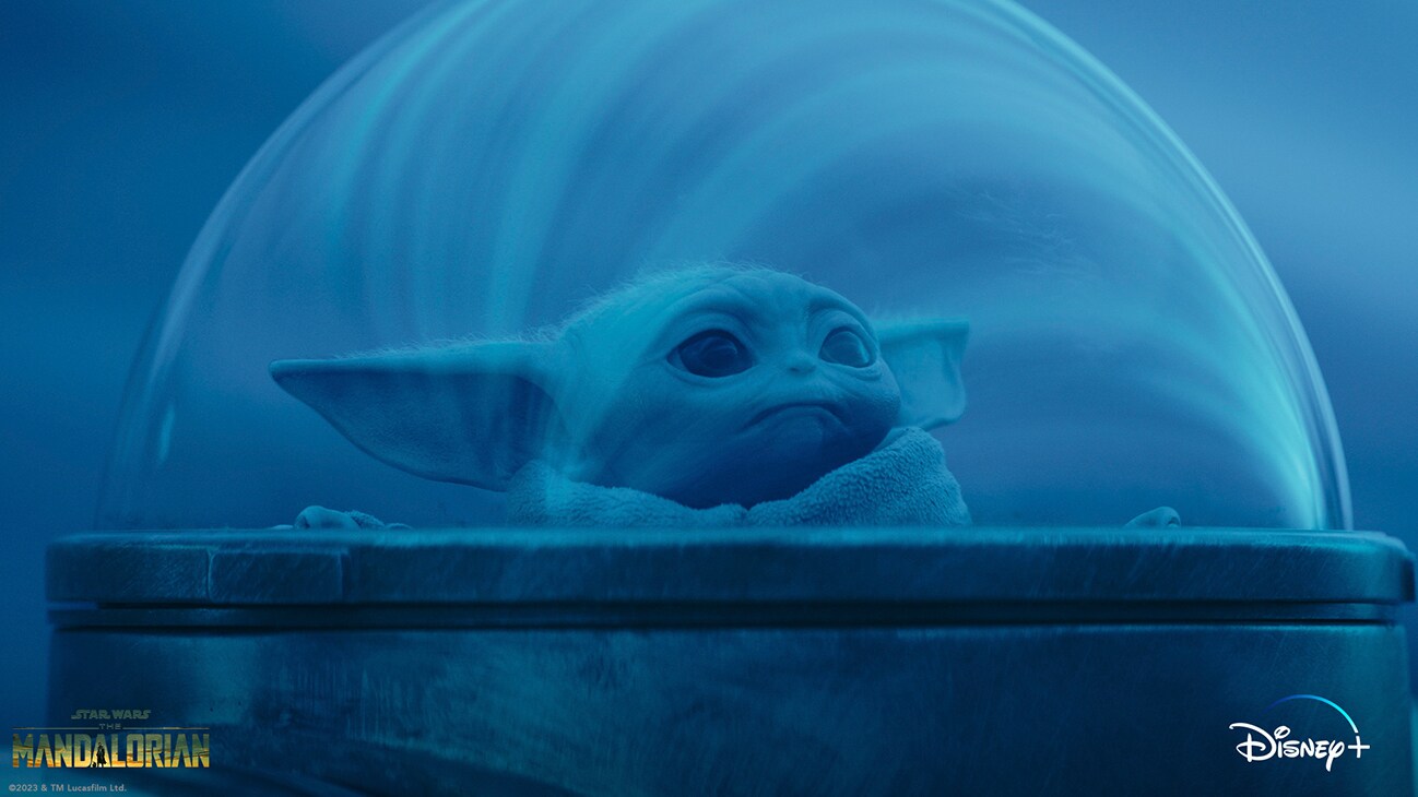 Grogu peering out of a starship's bubble window from the Disney+ Original series, "Star Wars: The Mandalorian Season 3."