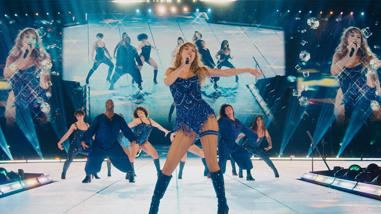 Image of Taylor Swift singing on a stage from the Disney+ Original movie, "Taylor Swift | The Eras Tour (Taylor’s Version)."