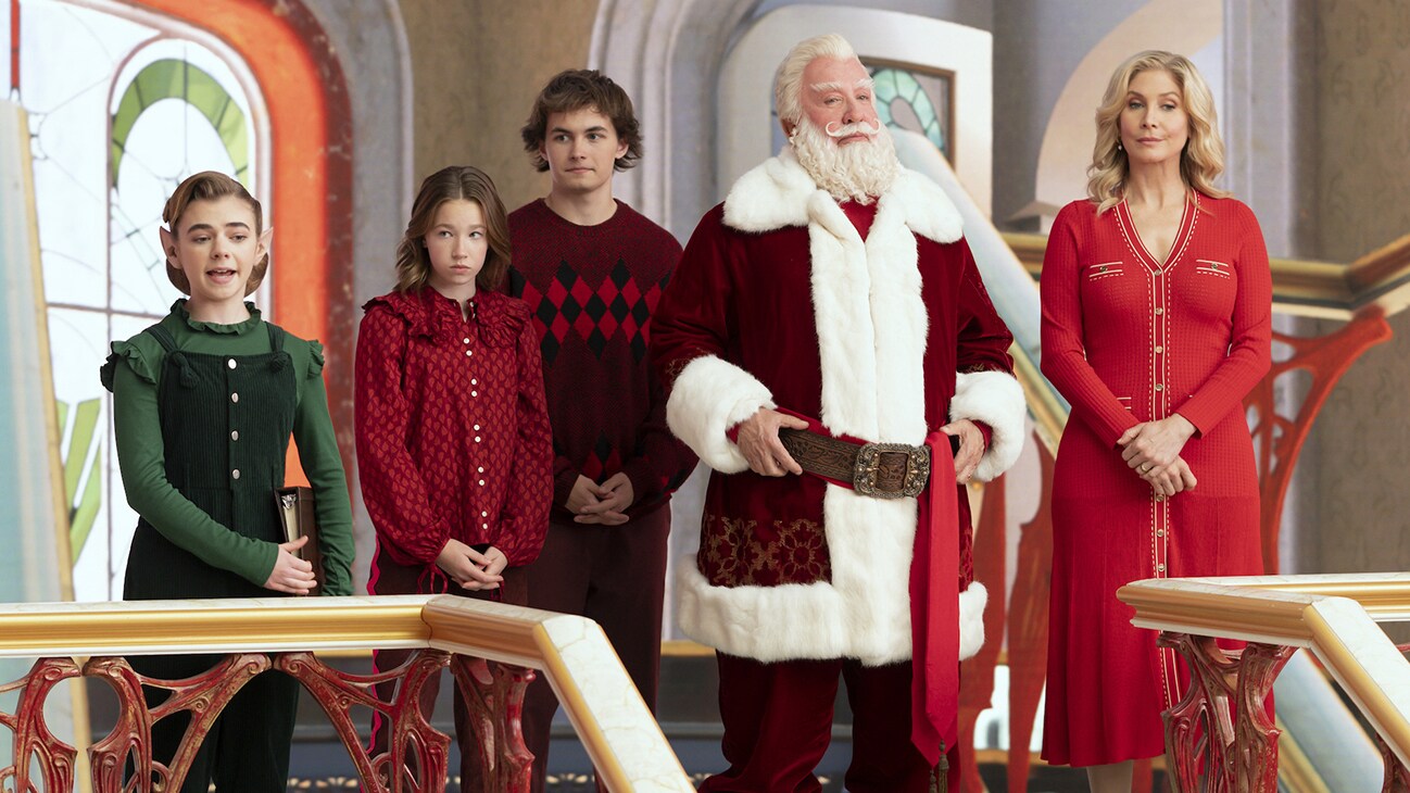 (L-R) Betty (Matilda Lawler), Sandra Calvin-Claus (Elizabeth Allen-Dick), Buddy Calvin-Claus (Austin Kane), Santa Claus (Tim Allen), and Mrs. Claus (Elizabeth Mitchell) from "The Santa Clauses (Season 1)," exclusively on Disney+.