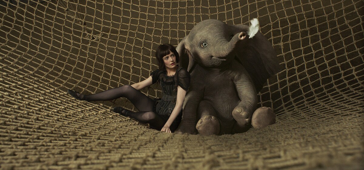 Eva Green (Colette Marchant) and Dumbo lay in a net from the movie "Dumbo"