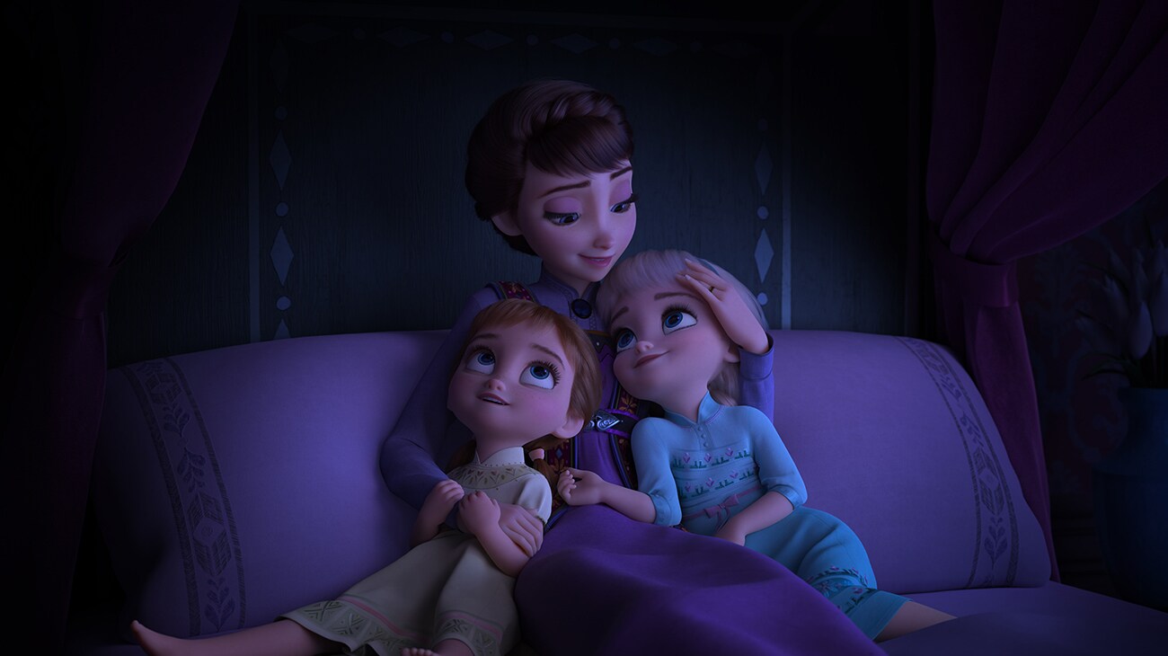 Queen Iduna, voiced by Evan Rachel Wood, hugging young Anna and Elsa in Frozen 2.
