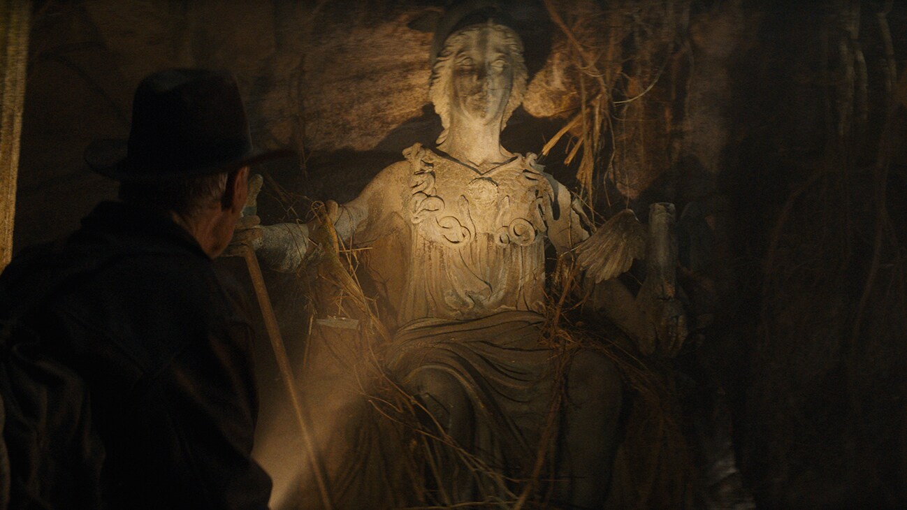 Indiana Jones (actor Harrison Ford) examines a statue from the Disney movie, "Indiana Jones and the Dial of Destiny."