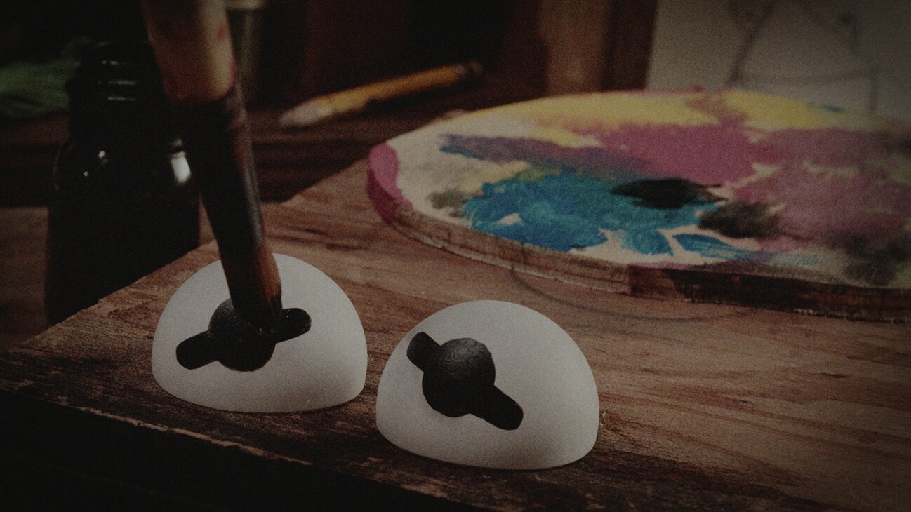 Image of two puppet eyes being painted on a workbench from the Disney+ Original documentary, "Jim Henson Idea Man."