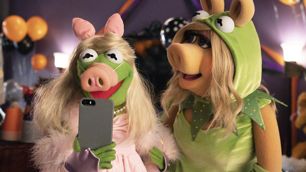 Image of Kermit the Frog and Miss Piggy dressed up as each other and taking a selfie from the Disney movie Muppets Haunted Mansion. (Disney/Mitch Haaseth)