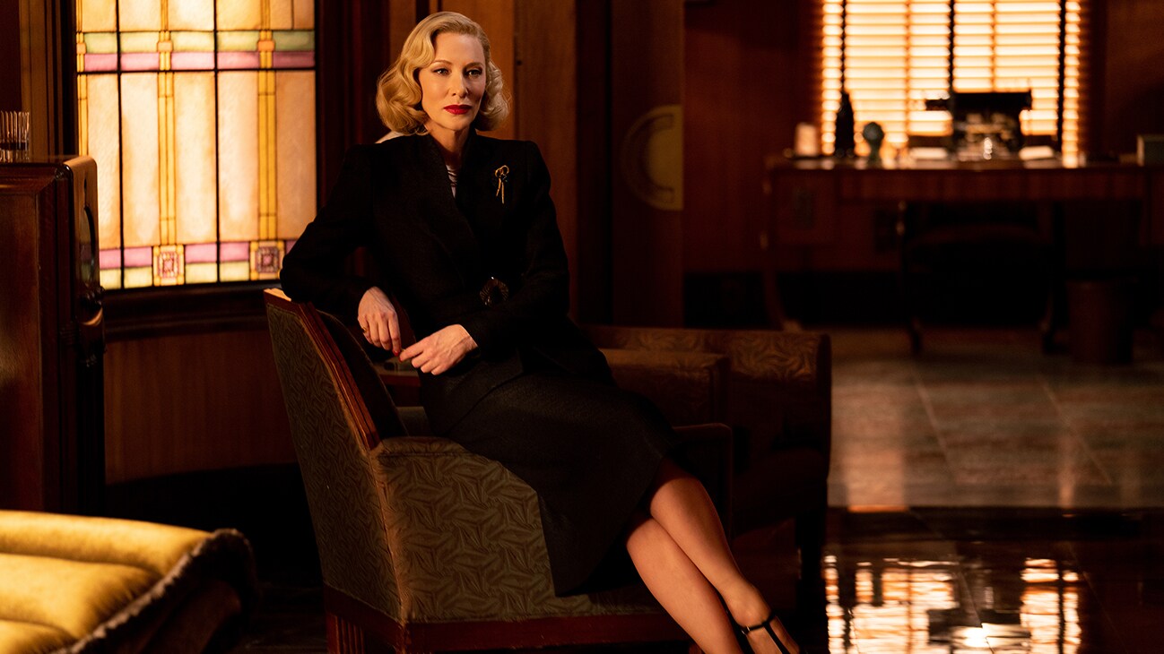 Cate Blanchett sits poised on a lounge sofa, from the 20th Century Studios movie, Nightmare Alley.