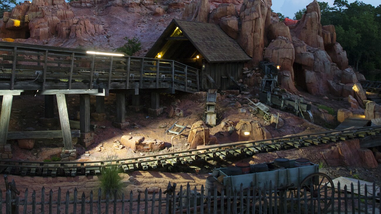 Image of a tracked section of the Big Thunder Mountain ride at night lit up.