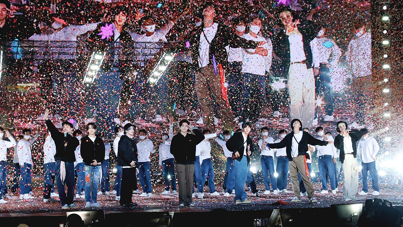 RM, Jin, SUGA, j-hope, Jimin, V and Jung Kook on stage while confetti falls from above from the Disney+ docuseries, "BTS Monuments: Beyond The Star."