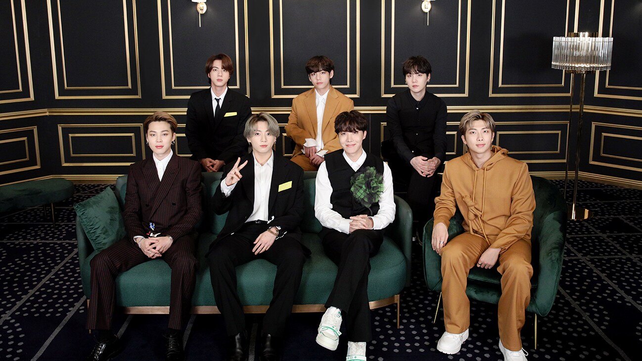 RM, Jin, SUGA, j-hope, Jimin, V and Jung Kook sitting on a sofa from the Disney+ docuseries, "BTS Monuments: Beyond The Star."