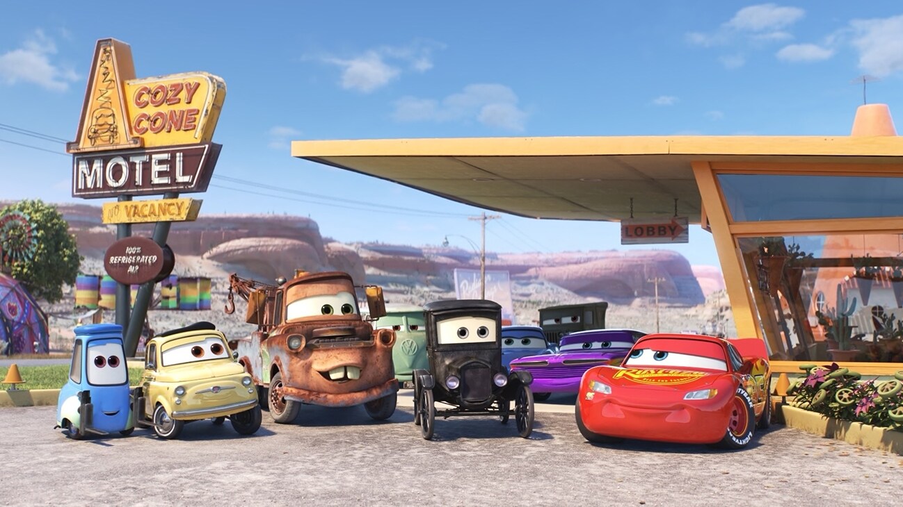Image of Guido, Luigi, Mater, Lizzie, and Lightning McQueen in front of the Cozy Cone motel from the Disney+ Original series, "Pixar Popcorn".