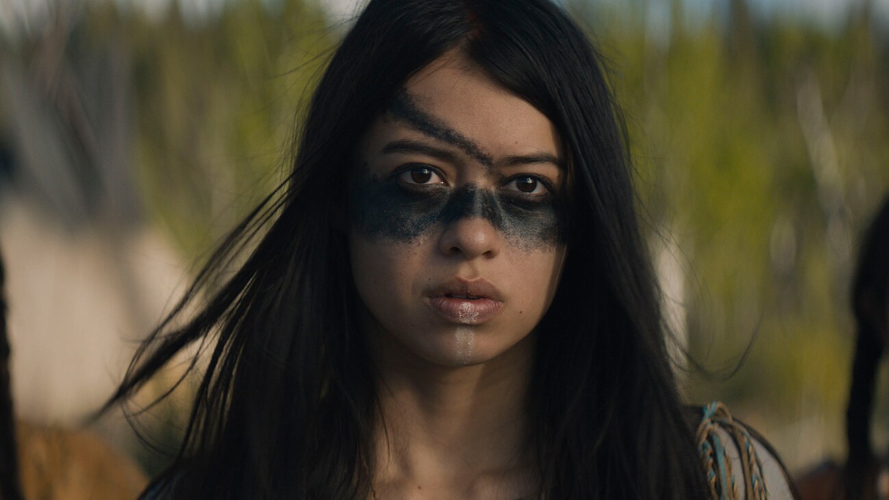 Image of a Native American with her face painted from the movie, "Prey".