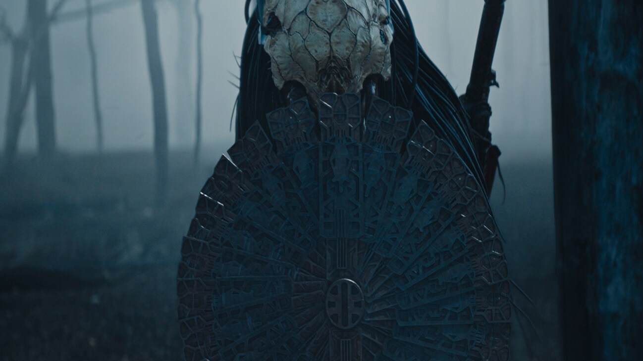 Image of the Predator holding a circular shield from the Hulu original movie, "Prey".
