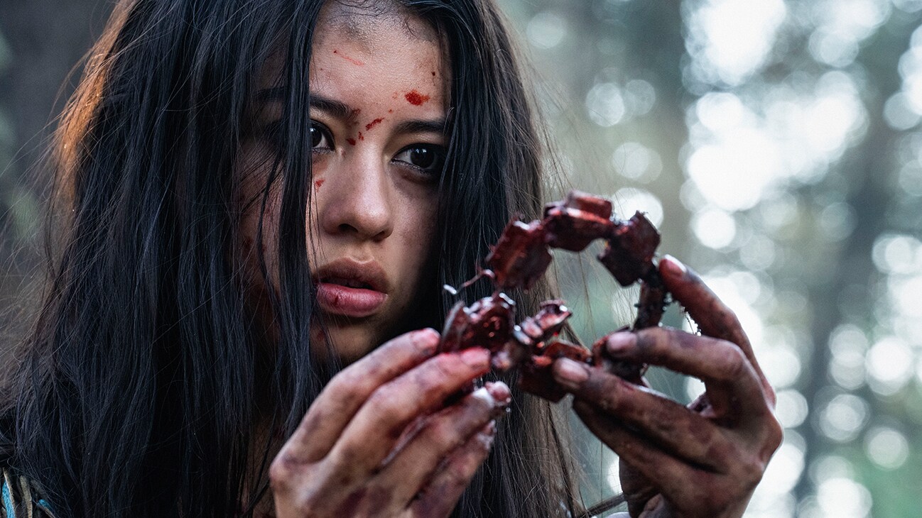 Naru (actor Amber Midthunder) holding an object from the Hulu original movie, "Prey".