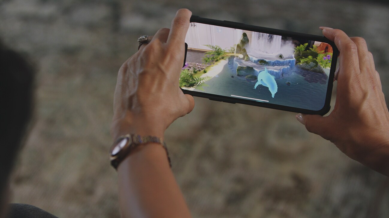 A mobile device showing a picture of an AR dolphin from the Disney+ AR short, "Remembering".