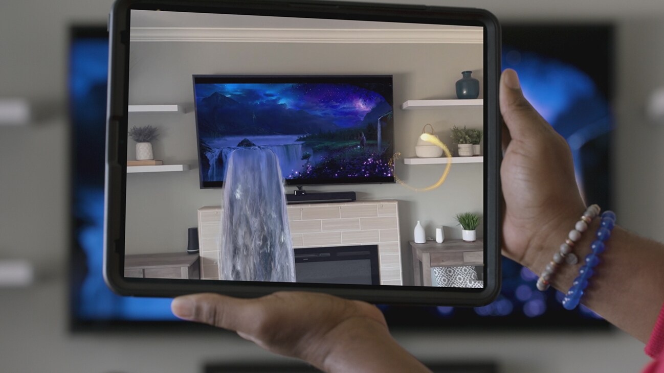 Close-up view of a waterfall pouring out of a TV as seen from a tablet device that is held in front of a TV from the Disney+ AR short, "Remembering".