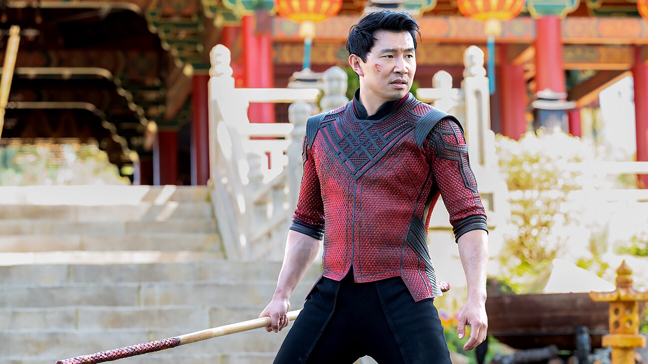 Shang-Chi (Simu Liu) holding a staff from Marvel Studios' Shang-Chi and The Legend of the Ten Rings.