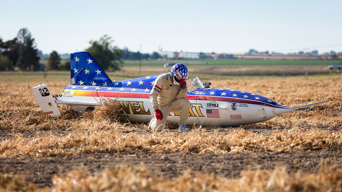 Image of Eddie Braun kneeling next to his rocket from the Disney+ Originals movie Stuntman. (Disney/ Steve Dondero)