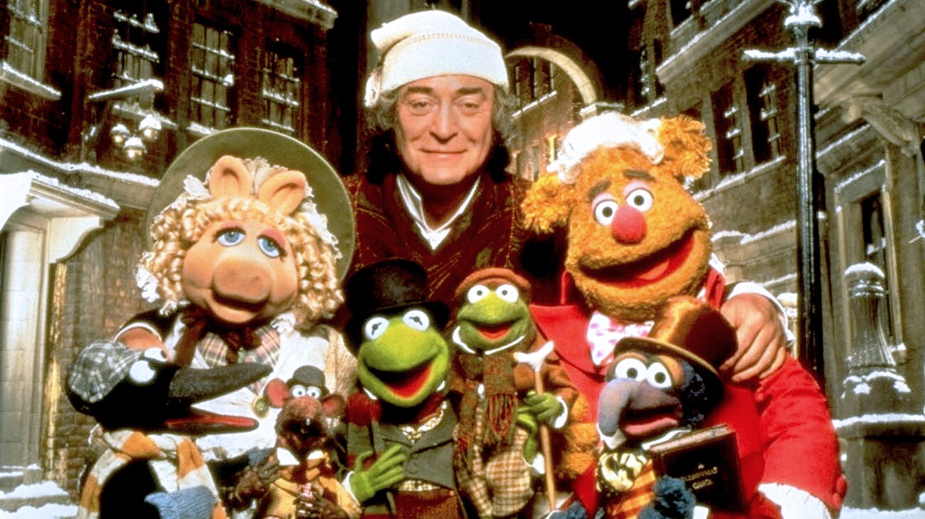 Ebenezer Scrooge (Michael Caine), The Great Gonzo as Charles Dickens (voice of Dave Goelz), Kermit the Frog as Bob Cratchet (voice of Steve Whitmire), Tiny Tim Cratchit (voice of Jerry Nelson), Miss Piggy as Emily Cratchit (voice of Frank Oz), and Fozzie Bear as Fozziwig (voice of Frank Oz), and Rizzo the Rat (voice of Steve Whitmire), in The Muppet Christmas Carol (1992)