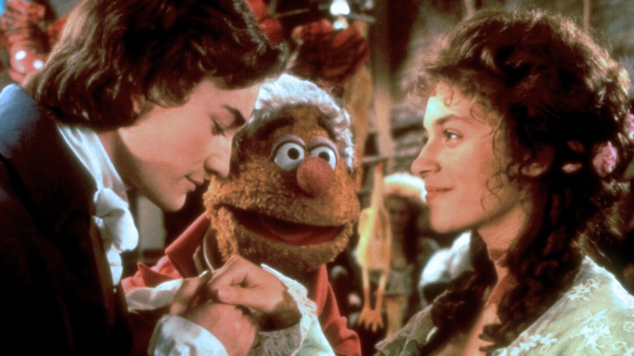 Fozzie Bear as Fozziwig (voice of Frank Oz), young Ebenezer Scrooge (Raymond Coulthard), and Belle (Meredith Braun) from the Disney movie The Muppet Christmas Carol.