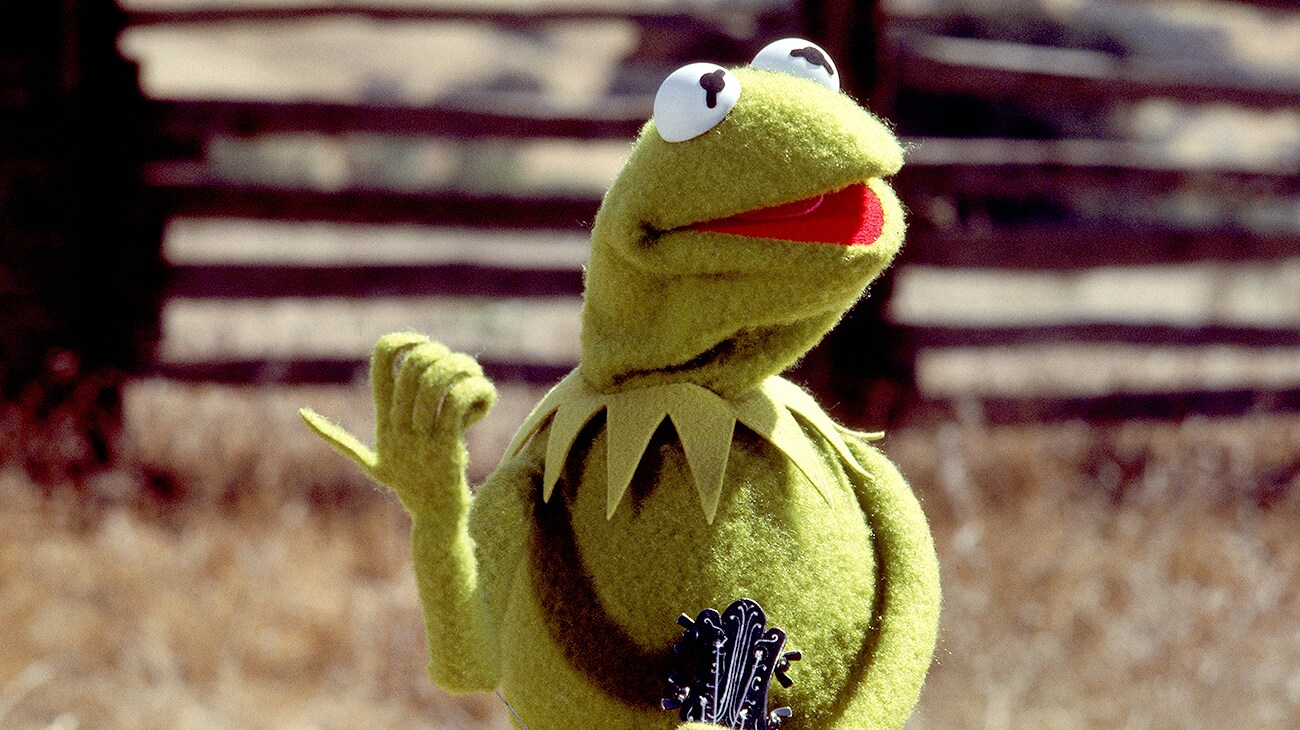 Kermit holds his thumb out to hitch hike in The Muppet Movie