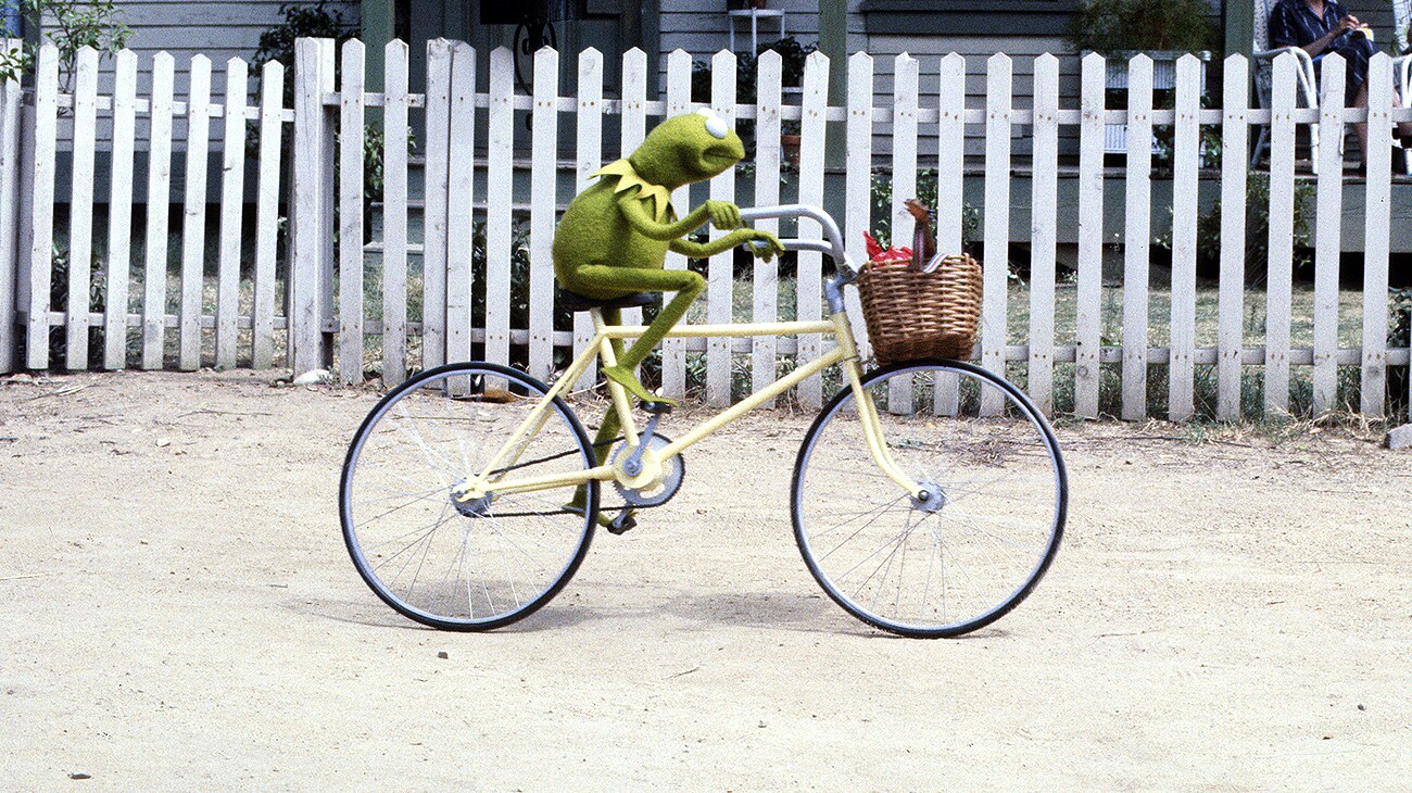 Kermit the Frog riding a bike in The Muppet Movie