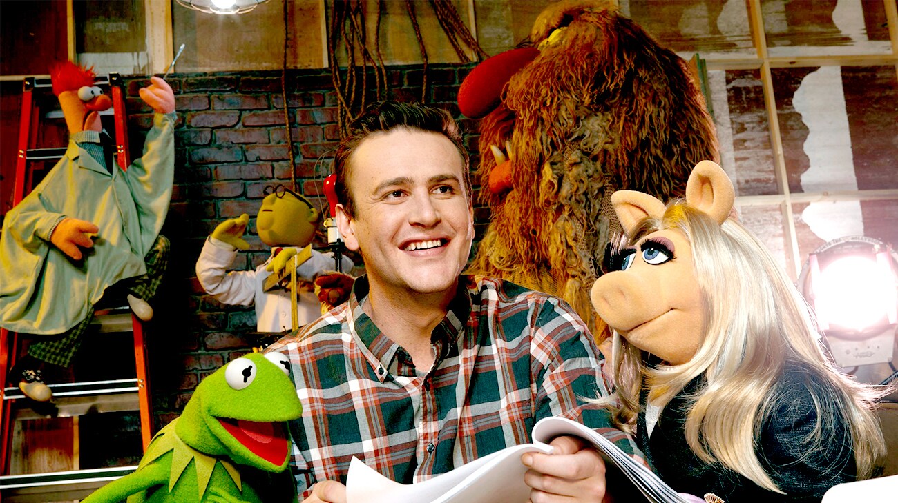 Jason Segel as Gary holding a script with Kermit and Miss Piggy