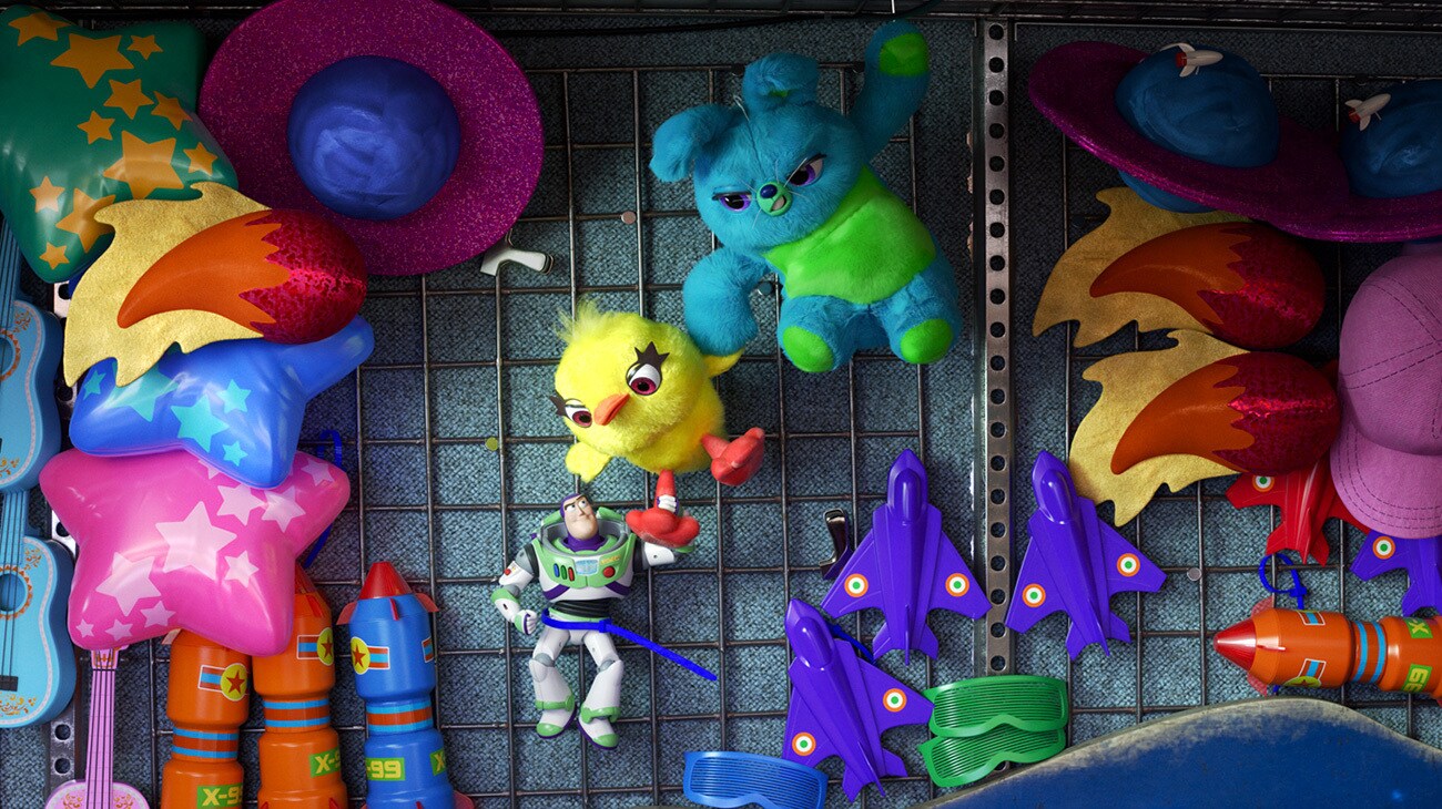 Buzz, Ducky and Bunny hanging on the wall of a carnival game booth in the animated movie "Toy Story 4"