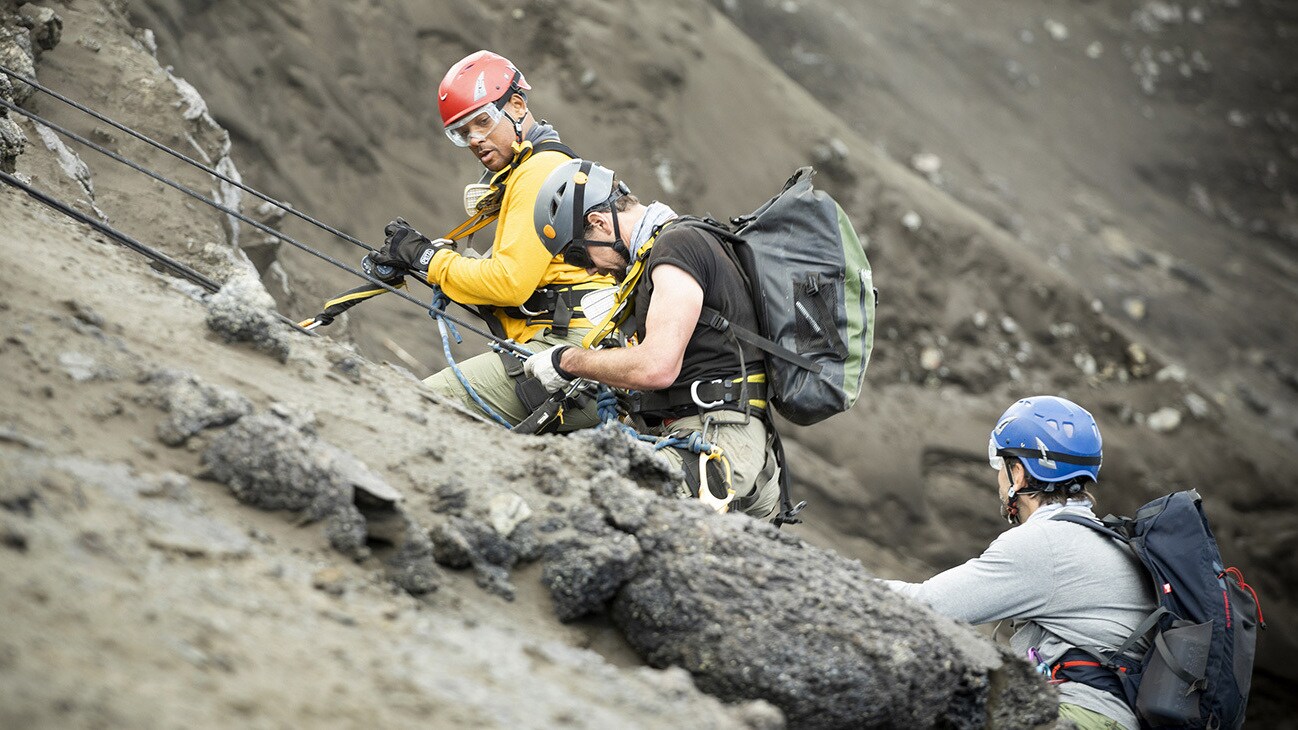 (L to R): Will Smith, Vulcanologist Jeff Johnson and Explorer Erik Weihenmayer descend into a volcano to install sensors. (National Geographic for Disney+/Kyle Christy)
