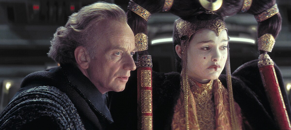 Senator Palpatine advising Queen Amidala during a session of the Senate