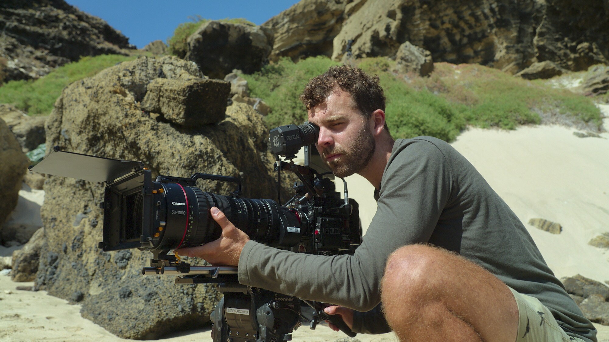 Sam Stewart filming on the beach holding. (National Geographic for Disney+/Anna Dimitriadis)