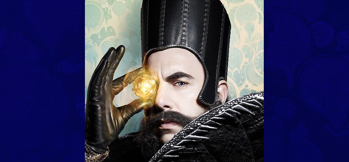 Sacha Baron Cohen as Time holding a glowing ball in the movie "Alice Through the Looking Glass"