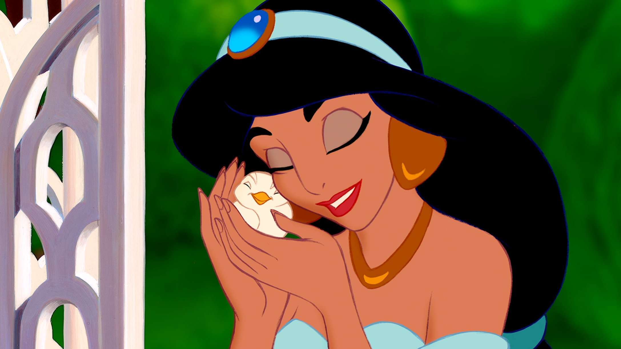 Jasmine petting a small bird outside in her courtyard. 