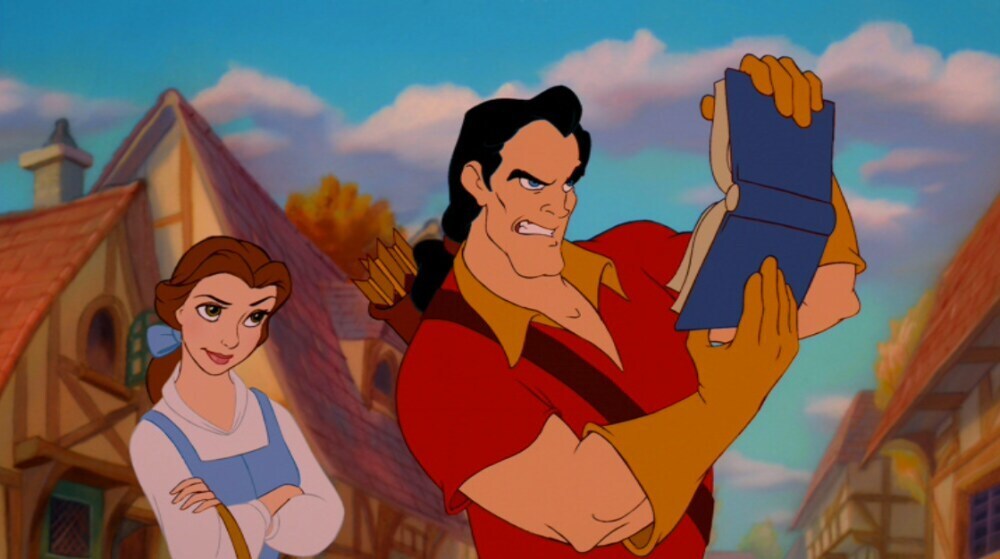 Belle behind Gaston as he tilts a book sideways