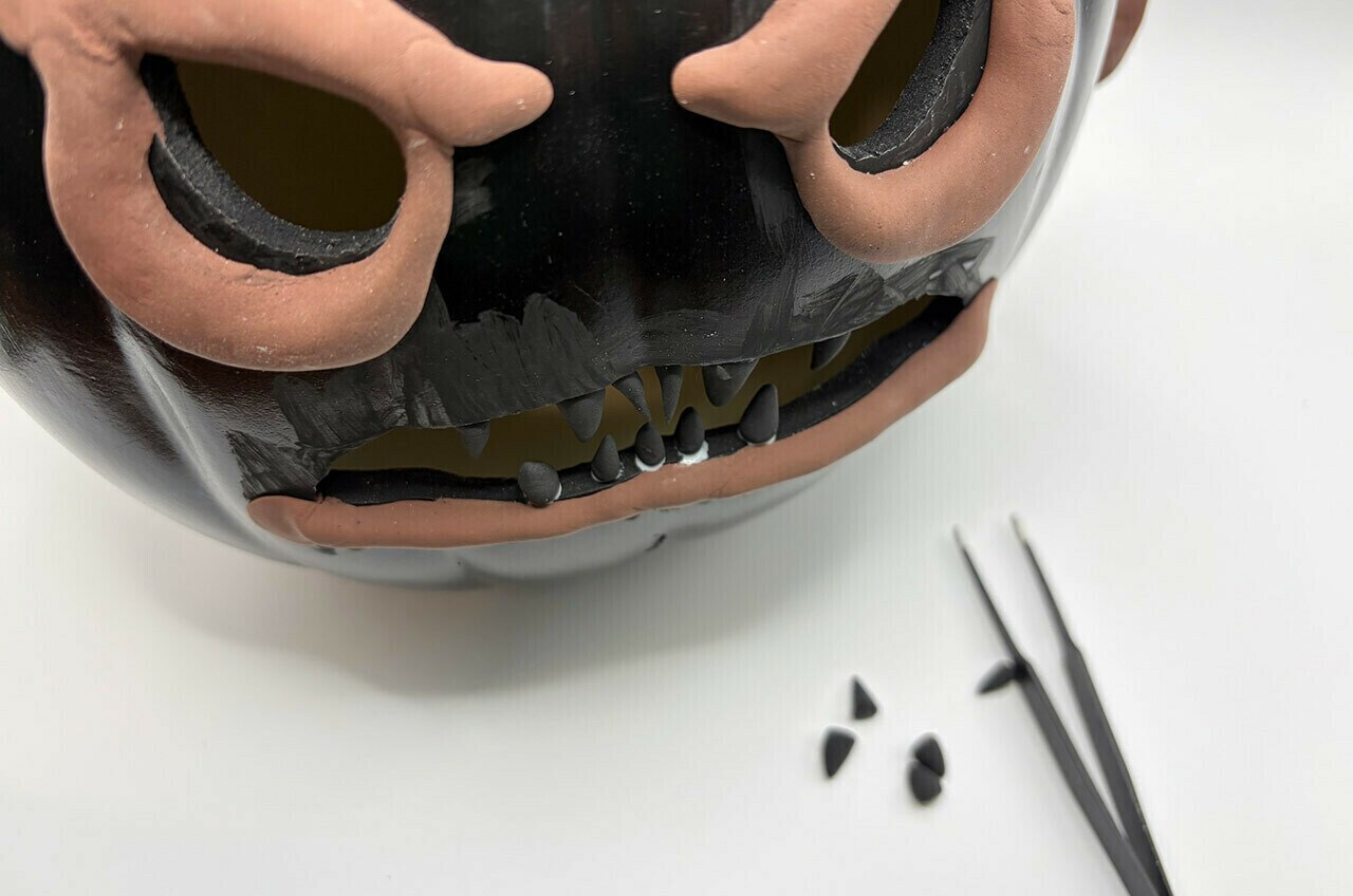 Make small cones from the modeling clay for the Amani’s teeth.