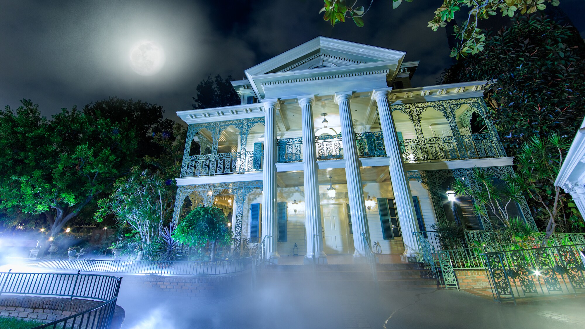 Image of the Haunted Mansion exterior at night.