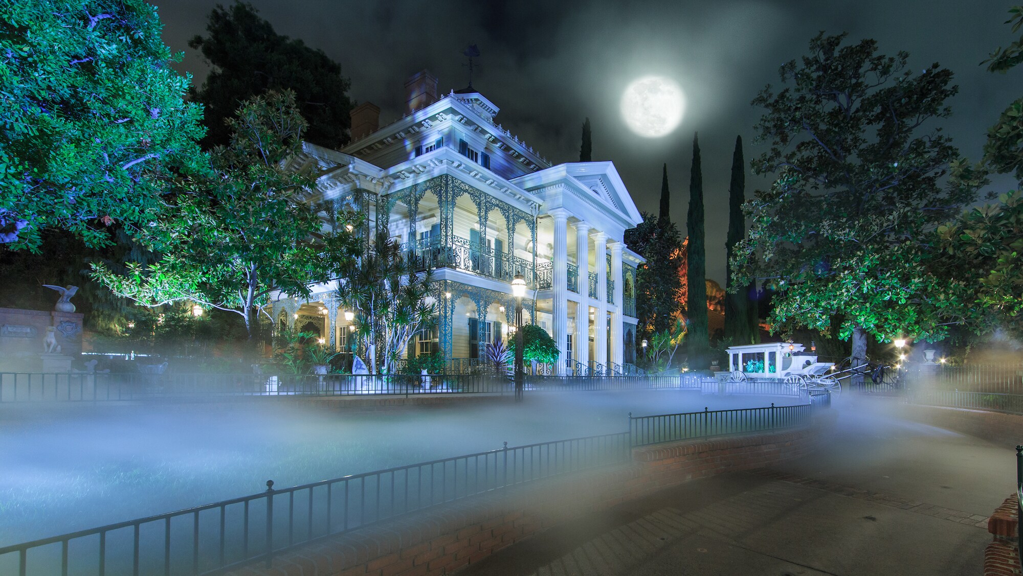 Image of the Haunted Mansion exterior at night.