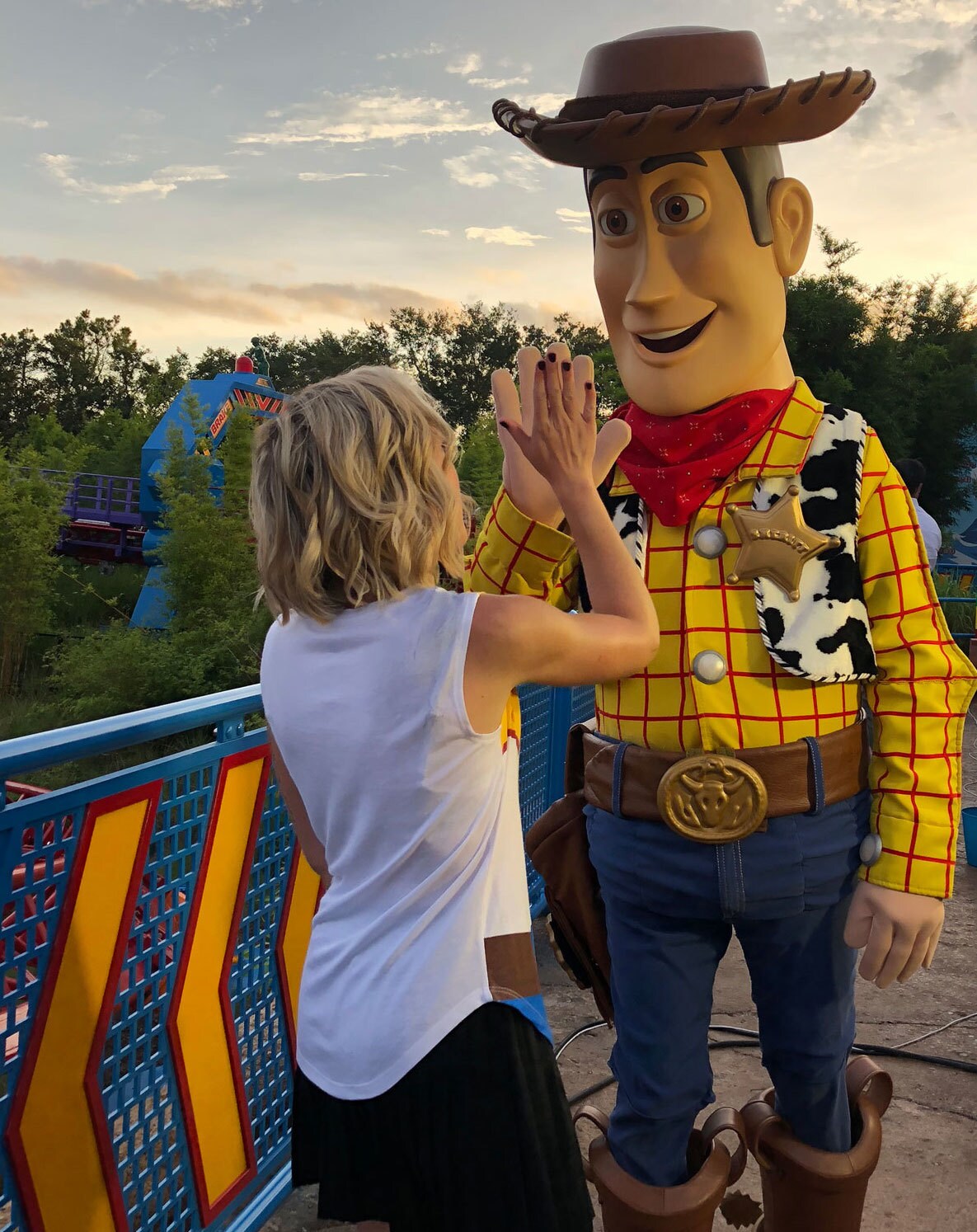 Oh My Disney Host Michelle Lema High fiving Woody in Toy Story Land at Walt Disney World