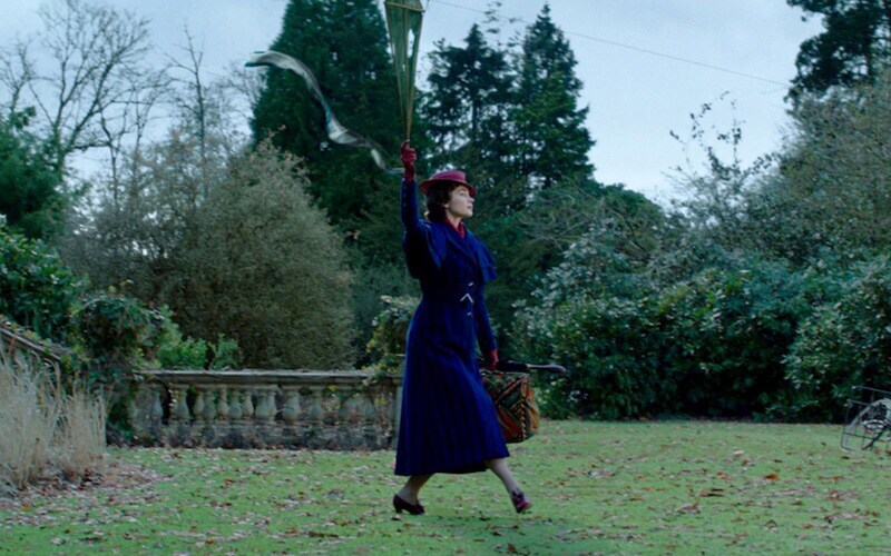 Mary Poppins landing in a park with an umbrella