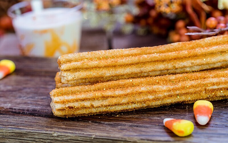 Orange Sugar Churros with candy corn sauce next to candy corn 