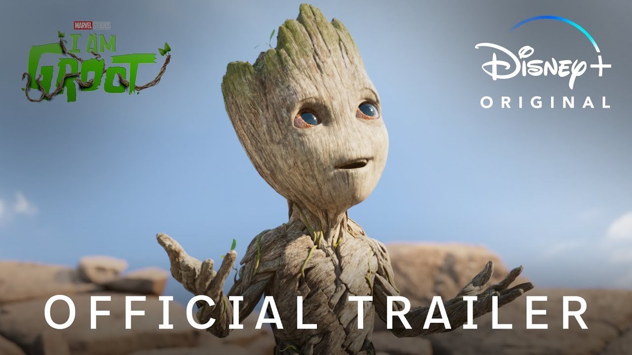 Groot smiles and holds his hands up in confusion, in what appears to be a desert-like landscape. The 'I Am Groot' title is in the top left hand corner of the image, 'Disney+' is in the top right, and 'Official Trailer' is in the foreground.