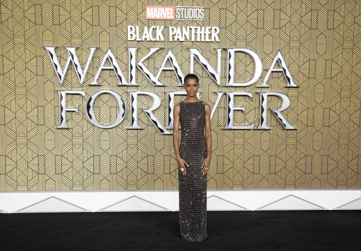Letitia Wright in front of Gold backdrop.