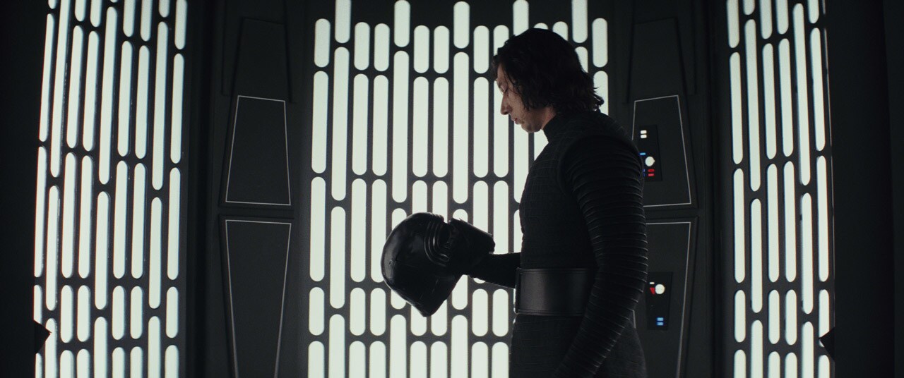 Kylo Ren looks down at his helmet in The Last Jedi.