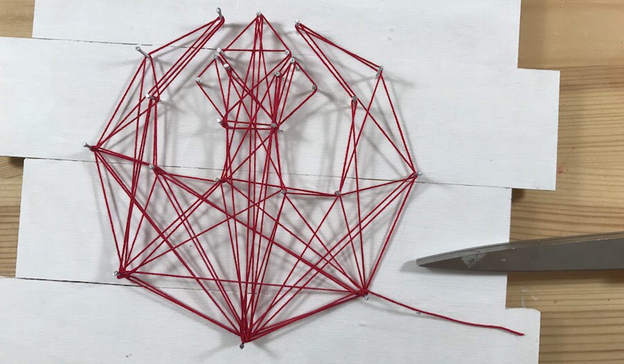 A string art craft in the shape of the Rebel insignia.