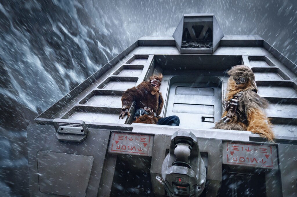 Han Solo and Chewbacca cling to the back of a conveyex during a heist in Solo: A Star Wars Story.