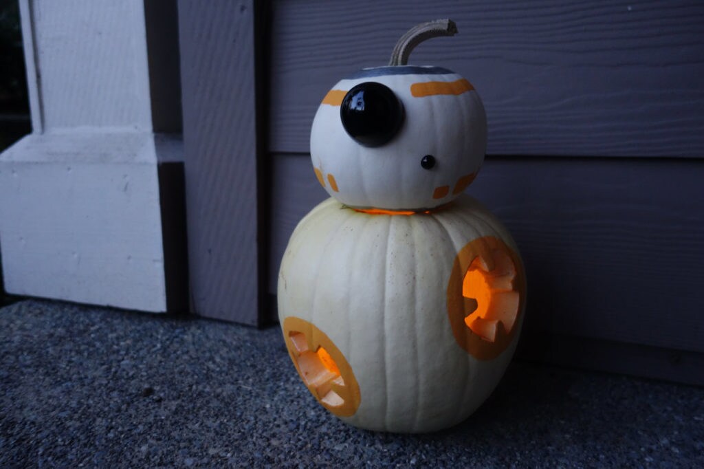 A jack-o-lantern made of 2 pumpkins painted and carved to look like BB-8.