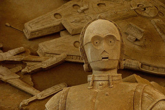 A Japanese sand sculpture of C-3PO standing in front of the Millennium Falcon and an X-wing Starfighter.