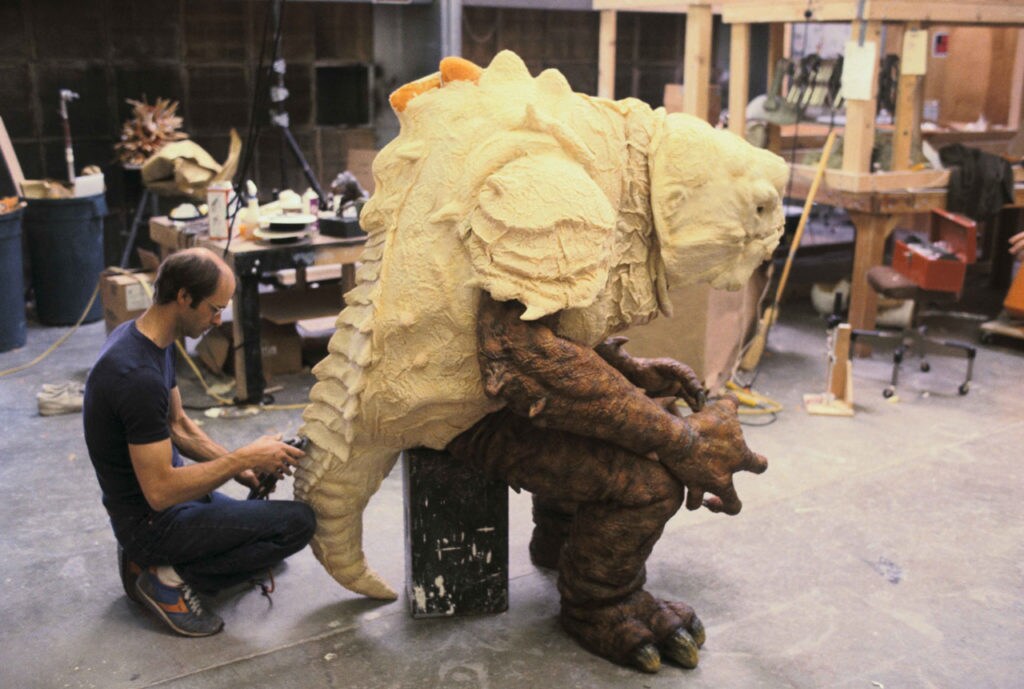 A special effects designer shapes the reptile-like tale of a rancor creature in his workshop during the production of Star Wars: Return of the Jedi.